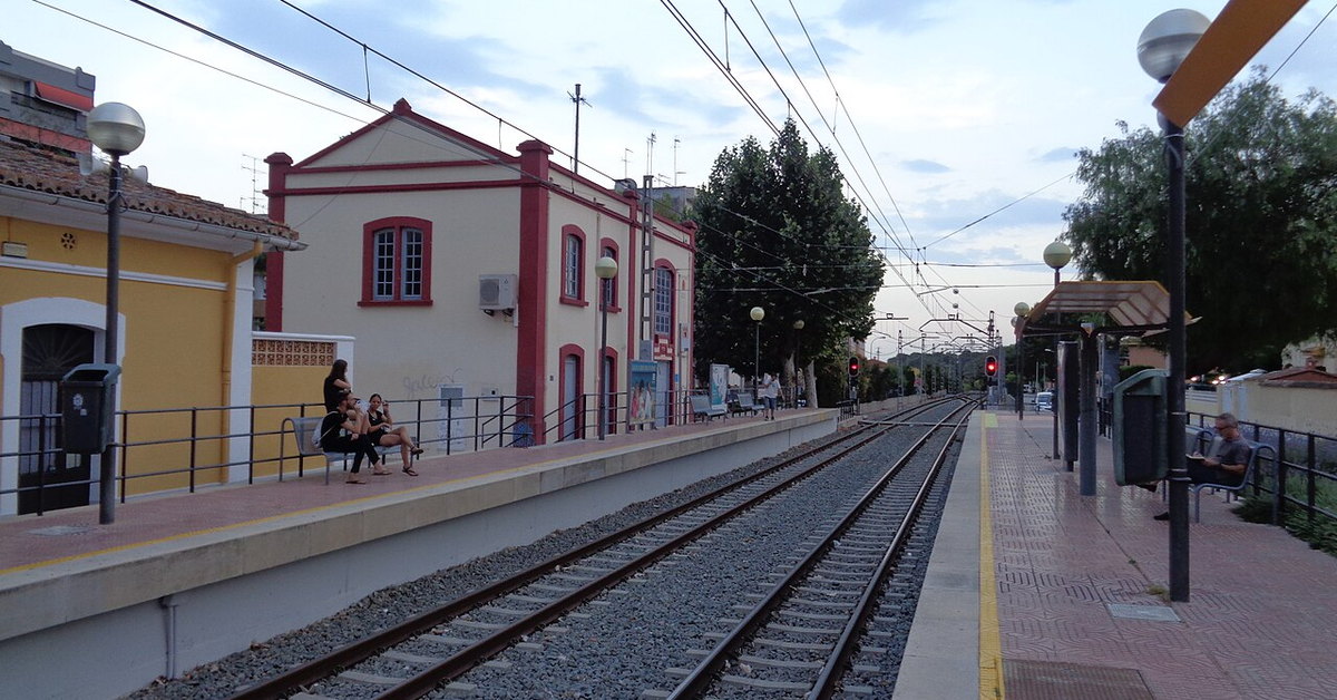 Andén de la estación de L’Eliana con el edificio de viajeros
