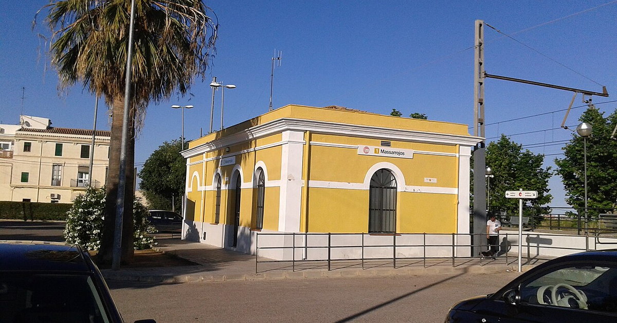 Edificio amarillo de la estación de Massarrojos entre palmeras